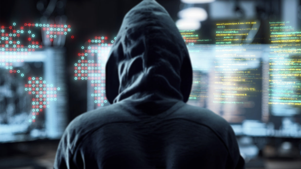 Hacker in front of computer screen of code