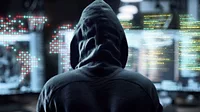 Hacker Hacker in front of computer screen of code