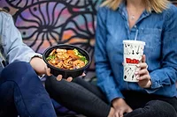 Fast-Casual Chain WaBa Grill Chooses Interface to Transform Its Network & Voice Infrastructure image of man and woman holding a meal from WaBa