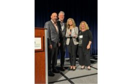 image of SDM Eidtor-in-Chief Karyn Hodgson (right) presenting the 2023 Dealer of the Year award to (from left) Don Weakley, Fred Johnson and Julie Weakley of PEAK Alarm.