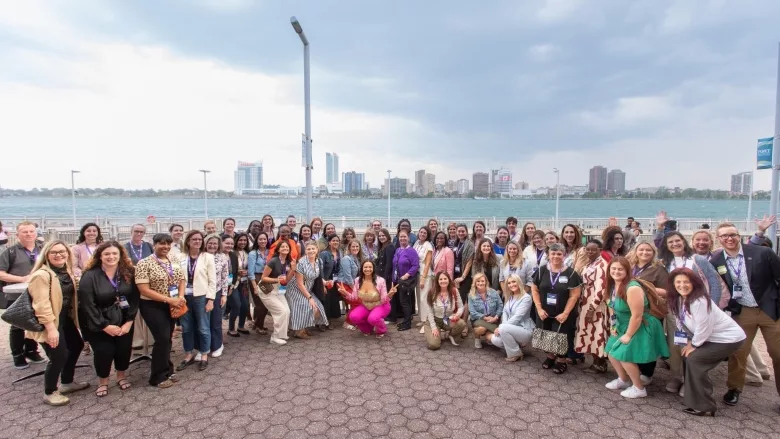 Image of attendees posing in front of the Detroit river.