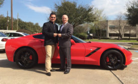 John Sullivan (right), senior vice president of sales at ADI, hands over the keys to a new Chevy Corvette to Ricky Gonzalez, owner of ACI Telephones in Houston, Texas.